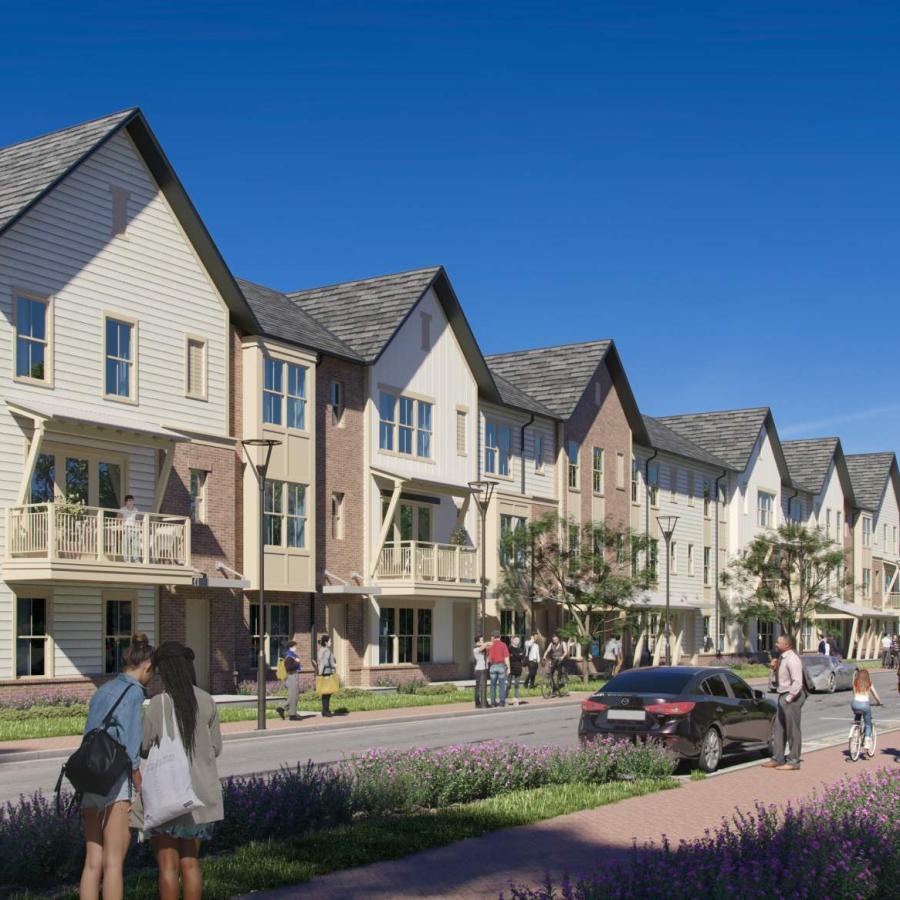 a group of people walking on a street next to a row of houses